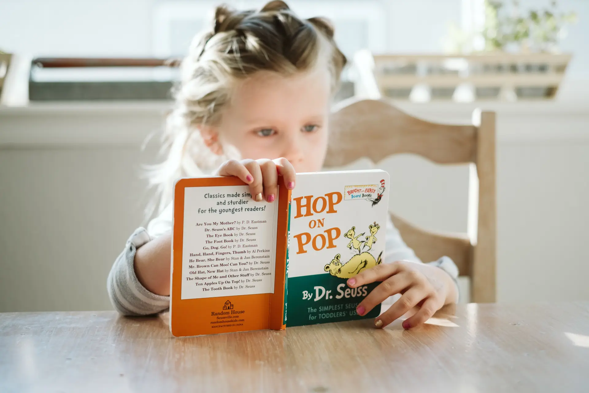 bambina piccola ha in mano un libro e legge